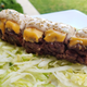 Big Mac sushi topped with melted cheese, special sauce, and sesame seeds on a bed of shredded lettuce
